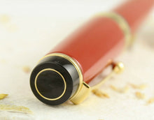 Load image into Gallery viewer, Angled view focusing on the tip of the cap. it features a small golden ring at the center. 
