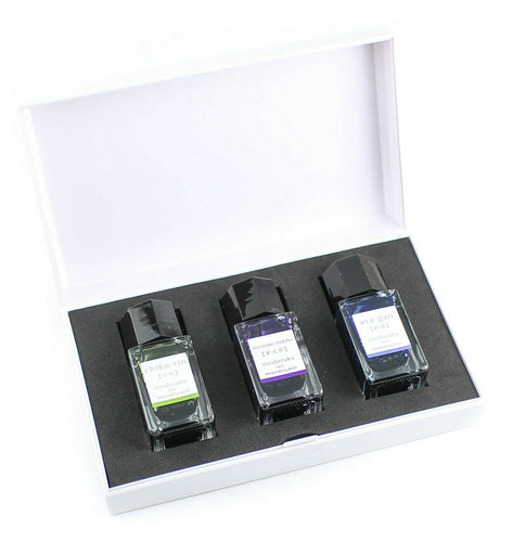The three ink bottles arranged inside their included white case. 