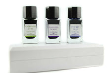 Load image into Gallery viewer, The three ink bottles placed on top of their carrying case. 
