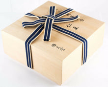 Load image into Gallery viewer, Angled view of the wooden presentation box with a blue and white bow ribbon tying it closed. The lid has handwritten text.
