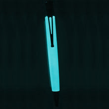 Load image into Gallery viewer, The White Retro 51 tornado pen shown as it glows in the dark. 

