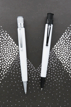 Load image into Gallery viewer, The Retro 51 classic white and the Chaplin side by side. The Chaplin has black trims and also glows in the dark. 

