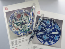 Load image into Gallery viewer, Front view of the Iznik Garden pen and pencil set, laid on two prints with images and details of the dishes.
