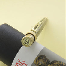 Load image into Gallery viewer, Top disk view of the pen, featuring The Met logo. The pen is leaning on the gift tube.
