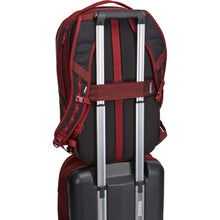 Load image into Gallery viewer, Back panel view of the backpack&#39;s attachment strap holding on to the extended handle on a suitcase. 
