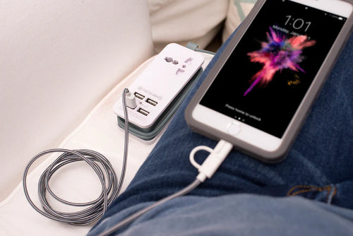 The adapter shown plugged, and charging a phone via a USB cable. 