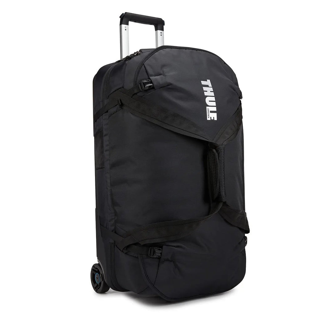Angled front panel view of the black wheeled duffle bag. The Thule logo is printed on the front panel. 