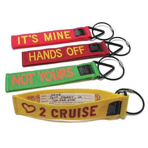 A set of four colorful luggage tags with text embroidery which reads: IT'S MINE, HANDS OFF, NOT YOURS, AND (HEART ICON) LOVE 2 CRUISE