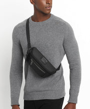 Load image into Gallery viewer, A young man wearing the waist pack as a sling bag.
