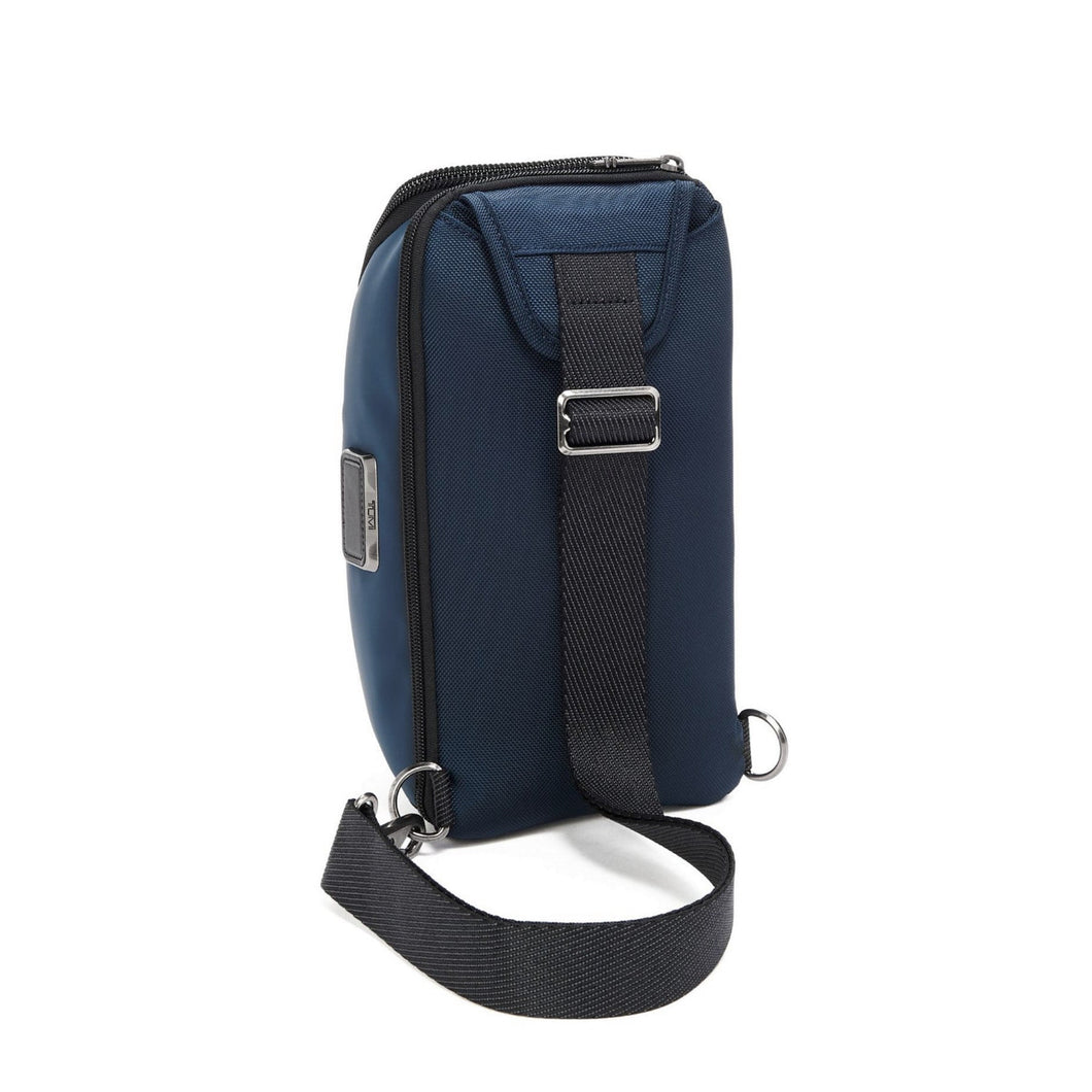 Angled back panel view of the Navy Blue bag, showing the adjustable black strap. 
