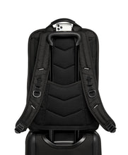 Load image into Gallery viewer, Back panel view of the backpack placed on top of a suitcase. The telescopic handle is passed through the backpack&#39;s back strap to hold it in place. 
