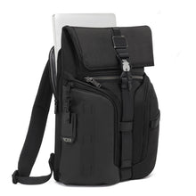 Load image into Gallery viewer, Angled front panel view of the backpack with a laptop peeking from its compartment. 
