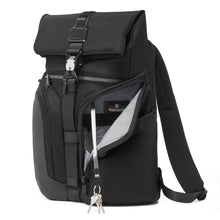 Load image into Gallery viewer, Angled front panel view of the backpack with one of the front pockets unzipped. A key lanyard is attached to the inside. 
