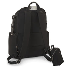 Load image into Gallery viewer, Angled back panel view of the backpack with a small bag attached to a ring on the adjustable shoulder strap.

