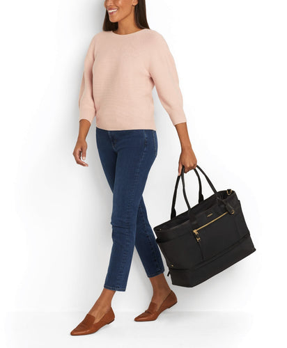 A young woman in casual clothes holding the bag by the handles. 