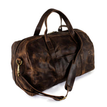 Load image into Gallery viewer, Angled front view of the brown distressed leather duffle bag. The shoulder strap is attached and resting at across the front of the bag. 
